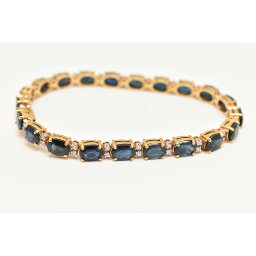 54 - A YELLOW METAL SAPPHIRE AND DIAMOND LINE BRACELET, designed with a row of twenty one oval cut blue s... 