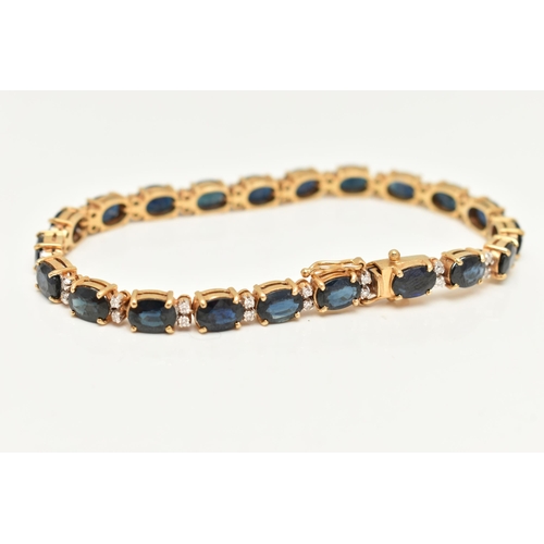 54 - A YELLOW METAL SAPPHIRE AND DIAMOND LINE BRACELET, designed with a row of twenty one oval cut blue s... 