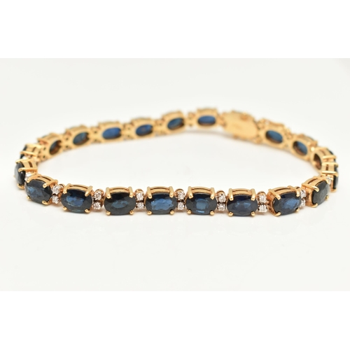 54 - A YELLOW METAL SAPPHIRE AND DIAMOND LINE BRACELET, designed with a row of twenty one oval cut blue s... 