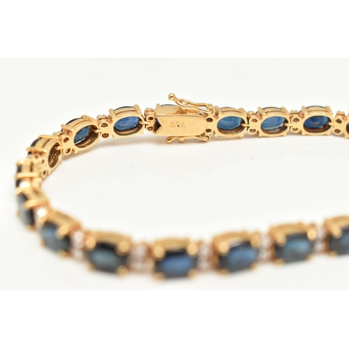 54 - A YELLOW METAL SAPPHIRE AND DIAMOND LINE BRACELET, designed with a row of twenty one oval cut blue s... 