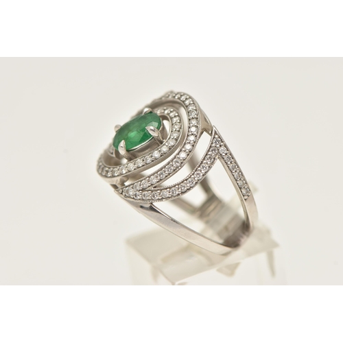 57 - A PLATINUM EMERALD AND DIAMOND DRESS RING, large dress ring set with a central oval cut emerald, in ... 