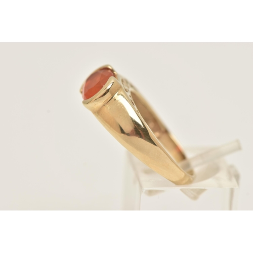 60 - A 9CT GOLD GEM SET RING, an oval cut faceted orange stone, assessed as fire opal, half bezel set in ... 