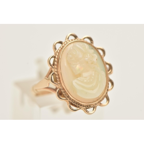 61 - A 9CT GOLD OPAL CAMEO RING, an oval opal carved with a cameo depicting a female portrait, collet set... 