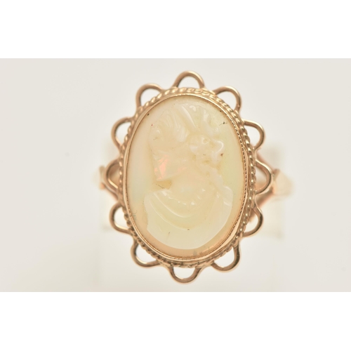 61 - A 9CT GOLD OPAL CAMEO RING, an oval opal carved with a cameo depicting a female portrait, collet set... 