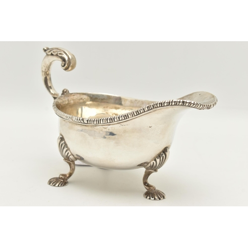 64 - A GEORGE V SILVER GRAVY BOAT, polished form with gadrooned rim, scrolling handle with leaf thumb res... 