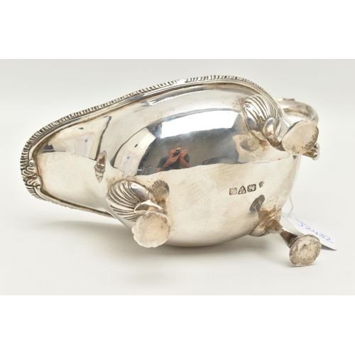 64 - A GEORGE V SILVER GRAVY BOAT, polished form with gadrooned rim, scrolling handle with leaf thumb res... 