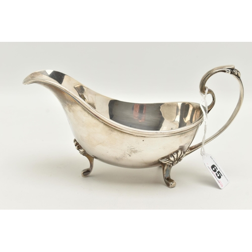 65 - AN ELIZABETH II SILVER GRAVY BOAT, polished form with scroll handle and shell detailed thumb rest, r... 