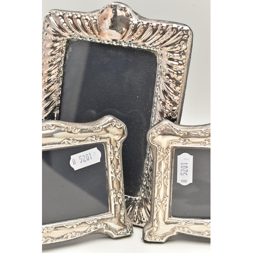 83 - FOUR SILVER PHOTOGRAPH FRAMES, to include two circular frames with inner beaded detail, an oval fram... 