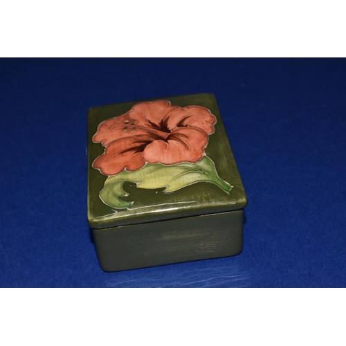 374 - A MOORCROFT POTTERY RECTANGULAR TRINKET BOX AND COVER, decorated in Coral Hibiscus pattern on a gree... 