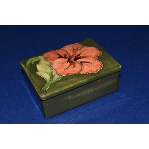 374 - A MOORCROFT POTTERY RECTANGULAR TRINKET BOX AND COVER, decorated in Coral Hibiscus pattern on a gree... 