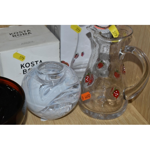 379 - A GROUP OF COLOURED STUDIO GLASS, a boxed Hadeland  45cl Jordbaer pitcher, a boxed Kosta Boda 'Blue ... 