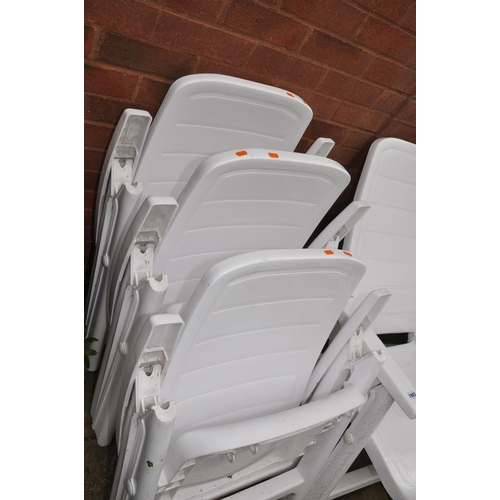 1022 - FOUR WHITE PLASTIC RECLINING GARDEN CHAIRS and three rattan style chairs with cushions (7)