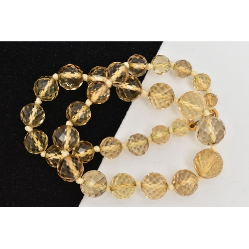 18 - A FACETED CITRINE BEAD NECKLACE, faceted round graduated citrine beads, individually knotted on a co... 