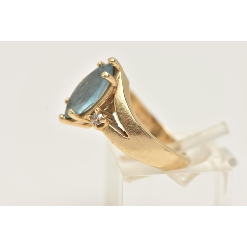 37 - A GEM SET RING, designed as a central marquise shape blue gem, assessed as topaz, flanked by brillia... 