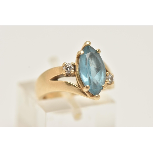 37 - A GEM SET RING, designed as a central marquise shape blue gem, assessed as topaz, flanked by brillia... 