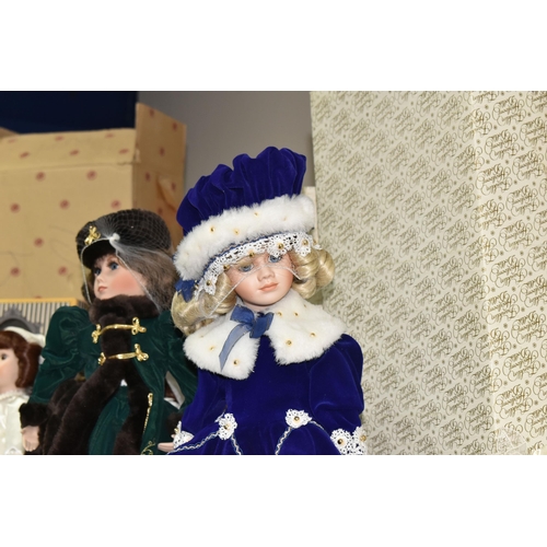 378 - A GROUP OF PORCELAIN DOLLS, comprising of four Franklin Heirloom dolls with boxes, one dressed in a ... 