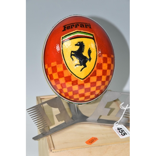 455 - A BOXED HANDPAINTED OSTRICH EGG, decorated with Ferrari emblem and F1 racing car, supported by a met... 