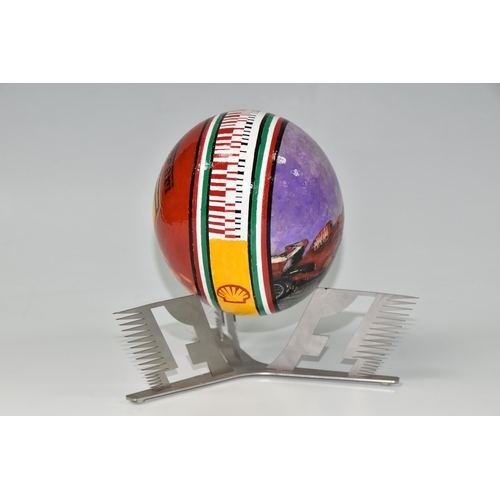 455 - A BOXED HANDPAINTED OSTRICH EGG, decorated with Ferrari emblem and F1 racing car, supported by a met... 