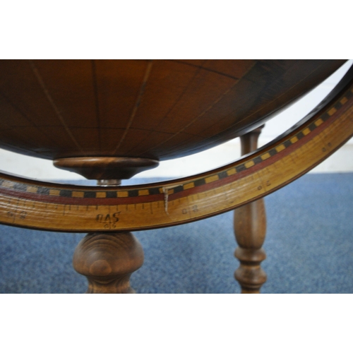 1202 - A 20TH CENTURY DRINKS GLOBE, the hinged lid enclosing a fitted interior, raised on turned supports, ... 