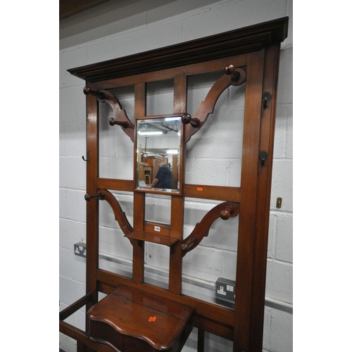 1203 - A 20TH CENTURY MAHOGANY HALL STAND, with a central bevelled edge mirror, seven pegs, three hooks, a ... 