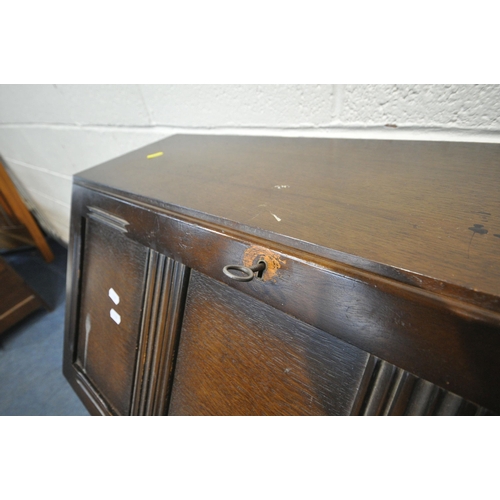 1244 - A 20TH CENTURY OAK BUREAU BOOKCASE, the double glazed door enclosing two shelves, atop a base with a... 