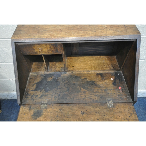 1284 - A 20TH CENTURY OAK BUREAU, the fall front door enclosing a fitted interior, above two drawers, raise... 