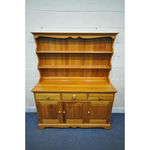 1287 - A MODERN PINE DRESSER, the two tier plate rack, atop a base with three drawers, above three cupboard... 