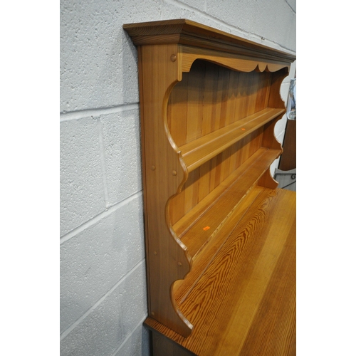 1287 - A MODERN PINE DRESSER, the two tier plate rack, atop a base with three drawers, above three cupboard... 