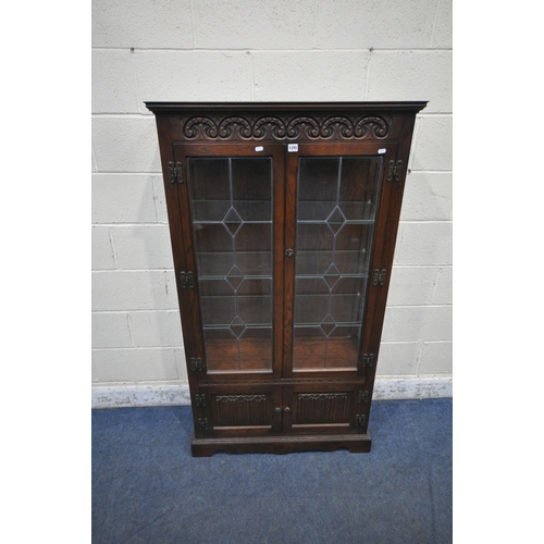 1295 - AN OLD CHARM OAK LEAD GLAZED DISPLAY CABINET, the double doors enclosing three glass shelves, above ... 