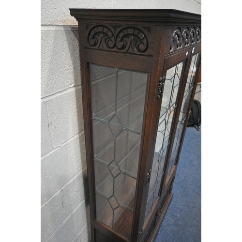 1295 - AN OLD CHARM OAK LEAD GLAZED DISPLAY CABINET, the double doors enclosing three glass shelves, above ... 