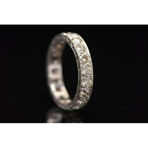 11 - A DIAMOND ETERNITY RING, designed as brilliant cut diamonds in a milligrain border, with engraved de... 