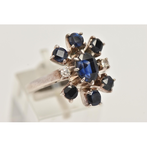 13 - A SAPPHIRE AND DIAMOND DRESS RING, designed as a central oval sapphire flanked by two single cut dia... 