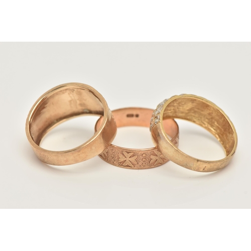 28 - TWO 9CT GOLD RINGS AND A YELLOW METAL RING, the first a wide tapering band ring with textured detail... 