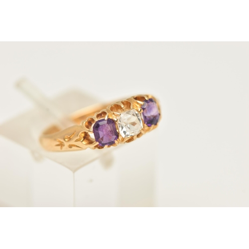 54 - AN 18CT GOLD AMETHYST AND PASTE RING, set with a cushion cut colourless paste, flanked with two rect... 