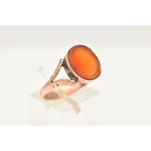 59 - AN EARLY 20TH CENTURY CARNELIAN RING, set with an oval carnelian panel, to the split scroll design s... 