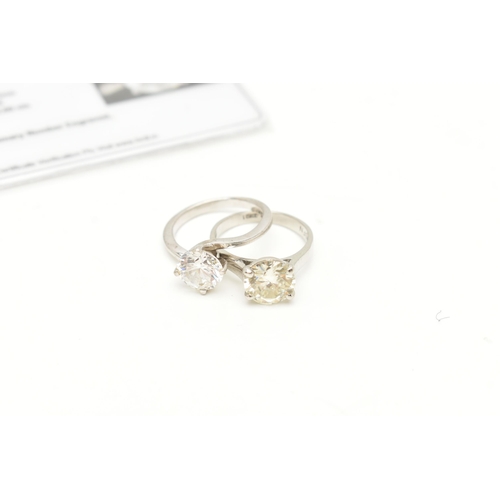 64 - A MOISSANITE WHITE METAL SINGLE STONE RING AND A PASTE WHITE METAL RING, the circular cut moissanite... 