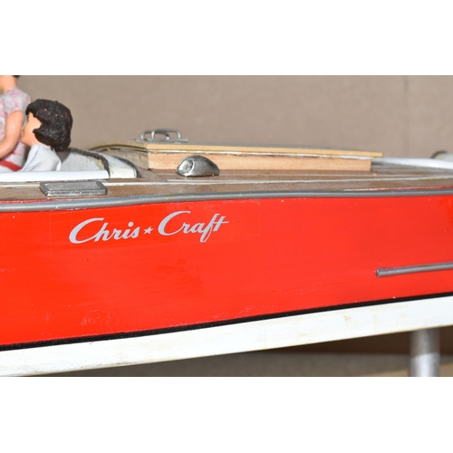 323 - A VINTAGE HANDICRAFTS 'CHRIS CRAFT' MODEL SPEED BOAT, 'Foxy Lady' fully assembled on a stand  and pa... 