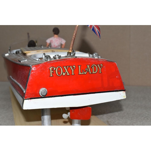 323 - A VINTAGE HANDICRAFTS 'CHRIS CRAFT' MODEL SPEED BOAT, 'Foxy Lady' fully assembled on a stand  and pa... 