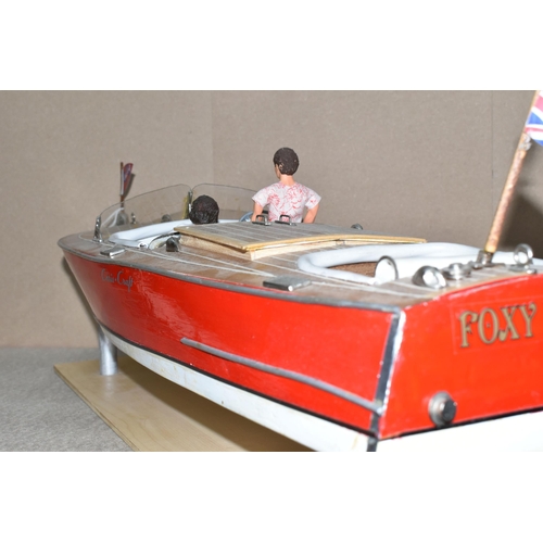 323 - A VINTAGE HANDICRAFTS 'CHRIS CRAFT' MODEL SPEED BOAT, 'Foxy Lady' fully assembled on a stand  and pa... 