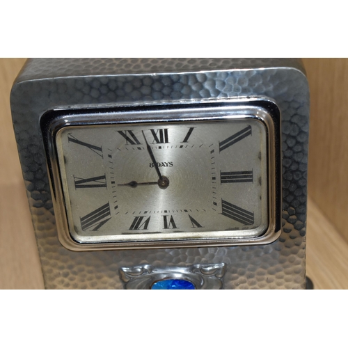 397 - A LIBERTY TUDRIC PEWTER EIGHT DAY MANTEL CLOCK, of rectangular form with hammered finish, raised on ... 