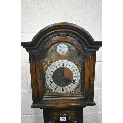 1204 - A 20TH CENTURY OAK CASE TEMPUS FUGIT CLOCK, the arched hood with a glass door, that's enclosing a br... 