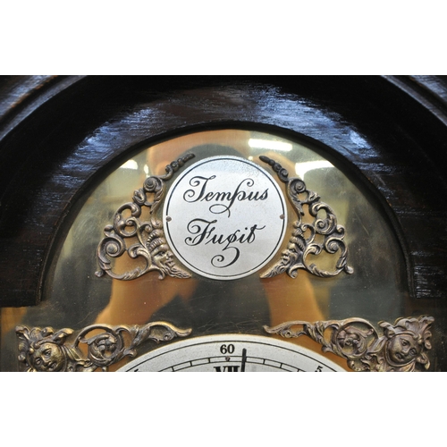 1204 - A 20TH CENTURY OAK CASE TEMPUS FUGIT CLOCK, the arched hood with a glass door, that's enclosing a br... 