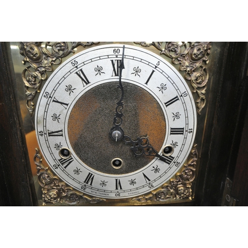 1204 - A 20TH CENTURY OAK CASE TEMPUS FUGIT CLOCK, the arched hood with a glass door, that's enclosing a br... 