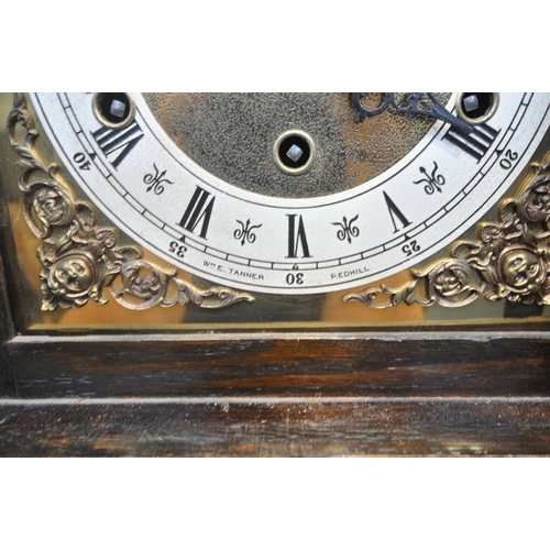 1204 - A 20TH CENTURY OAK CASE TEMPUS FUGIT CLOCK, the arched hood with a glass door, that's enclosing a br... 