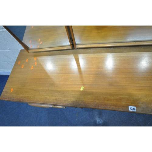 1228 - AN AUSTINSUITE MID CENTURY TEAK DRESSING TABLE, with a triple mirror, seven assorted drawers, raised... 