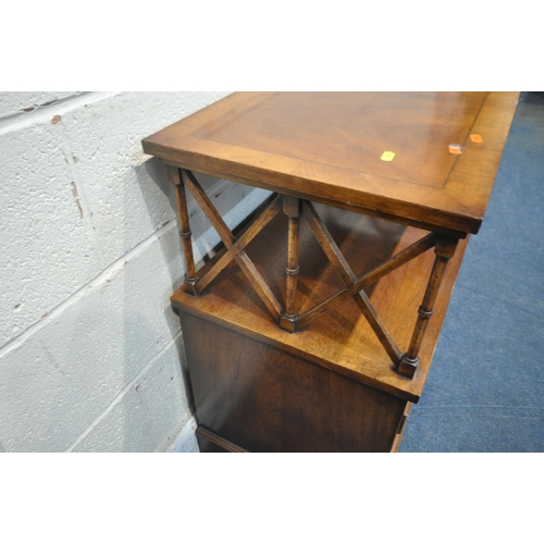 1240 - A REPRODUCTION MAHOGANY CABINET, the top surface raised on cross shaped and turned supports, above d... 