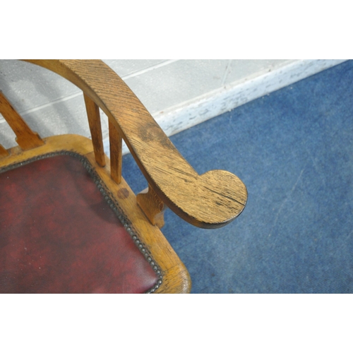 1273 - A 20TH CENTURY OAK OFFICE CHAIR, with swept armrests, oxblood leather seat pad, raised on four shape... 