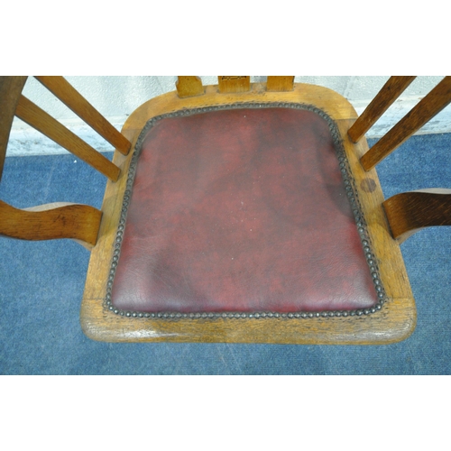 1273 - A 20TH CENTURY OAK OFFICE CHAIR, with swept armrests, oxblood leather seat pad, raised on four shape... 