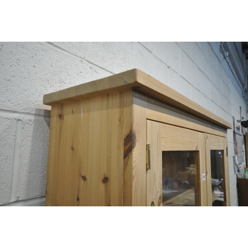 1305 - A MODERN PINE BOOKCASE, fitted with double glazed doors, above double cupboard doors, width 101cm x ... 