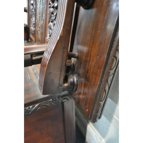 1315 - A 20TH CENTURY MAHOGANY MONKS BENCH, the tilting backrest with carved foliate details, that rest on ... 